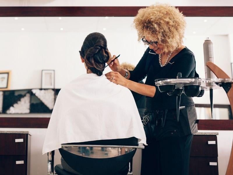 a woman at a hair salon assisting a customer
