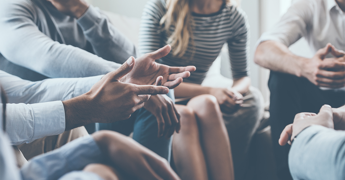 Man uses nonverbal communication while speaking in a meeting