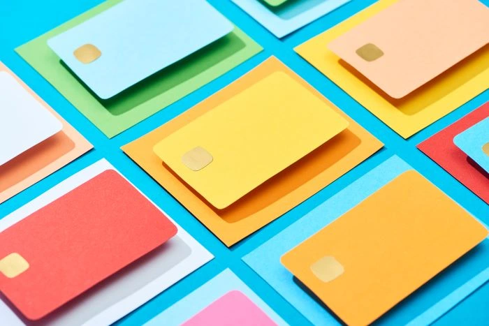 Colorful credit cards laid on a blue background ready for a merchant to accept credit card payments. 